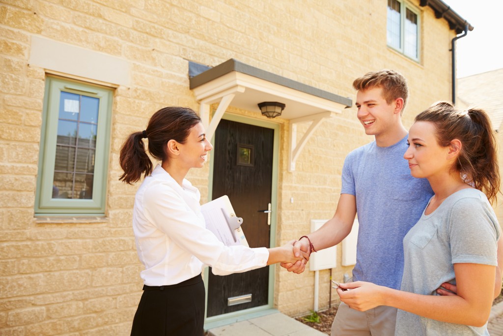 real estate agent shake hands with couple