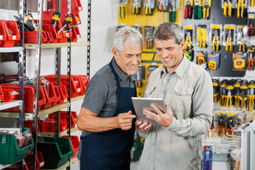 two men at a shop looking at tablet