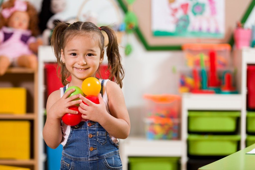 Preschooler holding colored balls