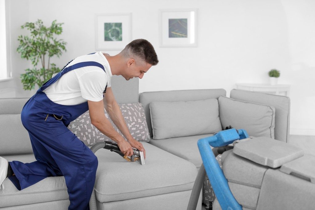 cleaner cleaning a home sofa