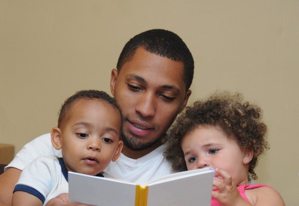 Father reading book with children